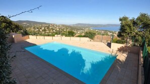 A rectangular swimming pool with a clear blue water surface, surrounded by a tiled deck.
