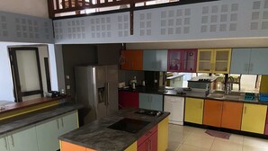 A kitchen with colorful cabinets, a refrigerator, a stove, and a sink. - Résidences Gamly (Mamoudzou)