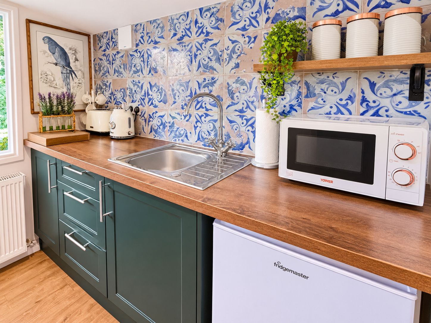 A kitchen with a sink, a microwave, and a toaster on the countertop.