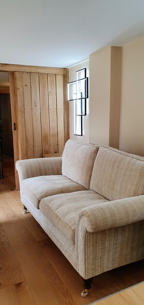 Relax in this stylish living room with a comfortable sofa, wooden floor, and large window.