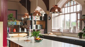 A kitchen with a large island, wooden cabinets, and pendant lighting. - Wesleyan, Bolton Abbey Estate (Barden)