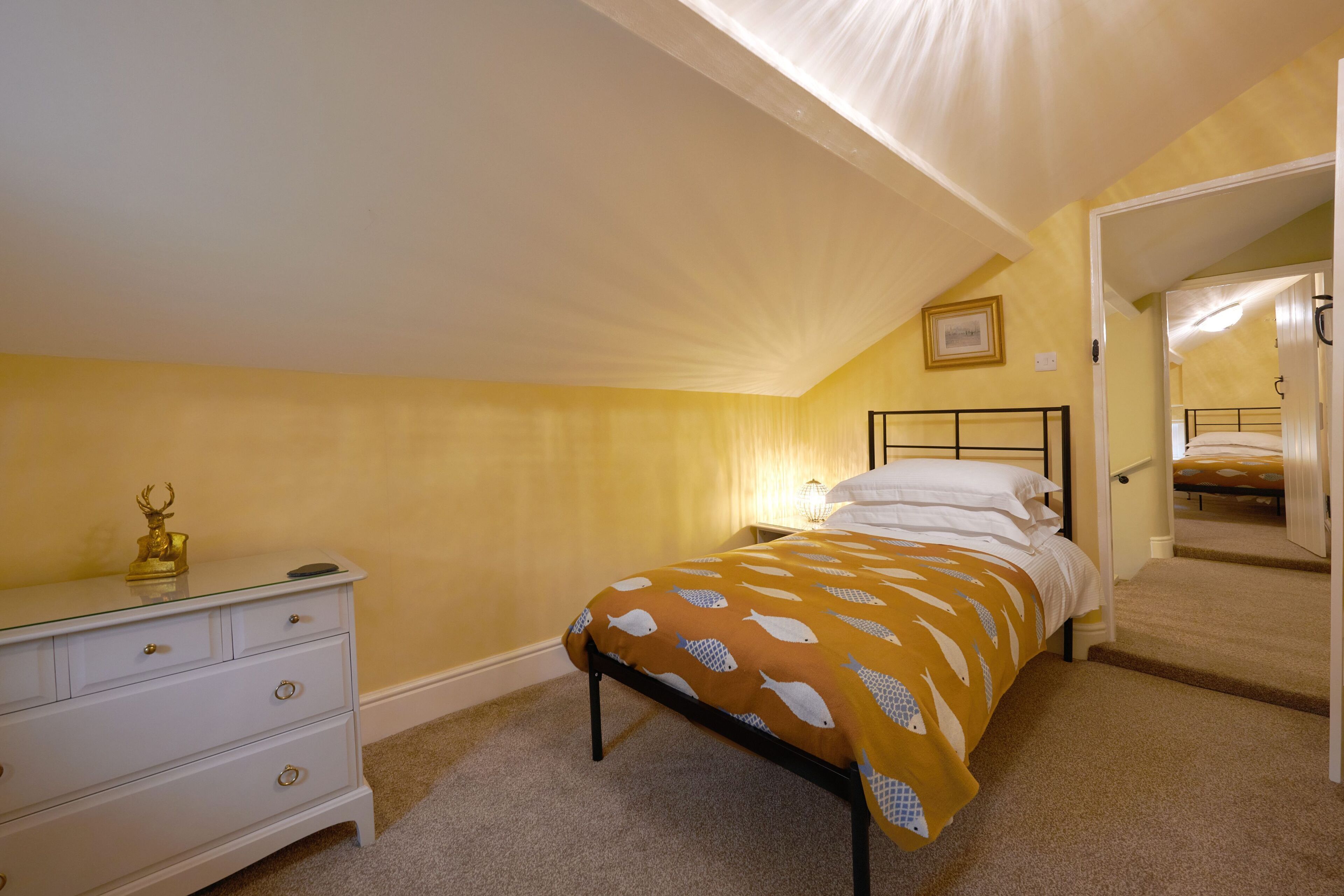 A bedroom with a bed, a dresser, and a mirror.