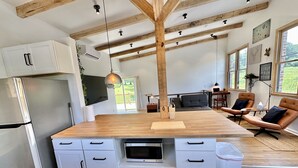 Une cuisine moderne dotée d’un îlot central, de meubles blancs et d’un réfrigérateur en acier inoxydable.
