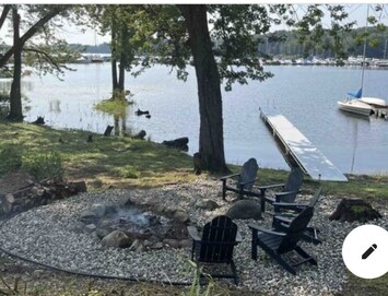 Fire pit down at water w/wood and 6 Adirondack chairs. 