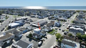 An aerial view of a residential area with houses, streets, and a beach in the background. - 231 33rd St Unit A  2BR Beach Home Hideaway  Parking (Brigantine)