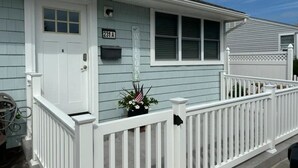 A light blue house with a white front door, a mailbox, and a small American flag decoration. - 231 33rd St Unit A  2BR Beach Home Hideaway  Parking (Brigantine)
