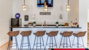 Angolo bar con una TV a parete, un cartello che indica l'ora felice e un cartello con il marchio Bud Light.