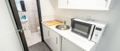 Estudio | Cocina privada | Refrigerador, parrilla de estufa y tetera eléctrica