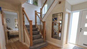A staircase with wooden railings and carpeted steps leading to a second floor. - Beech Lea (Ulverston)