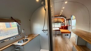 Une cuisine de taille réduite, équipée d’un évier, d’un plan de travail en bois et d’une fenêtre.