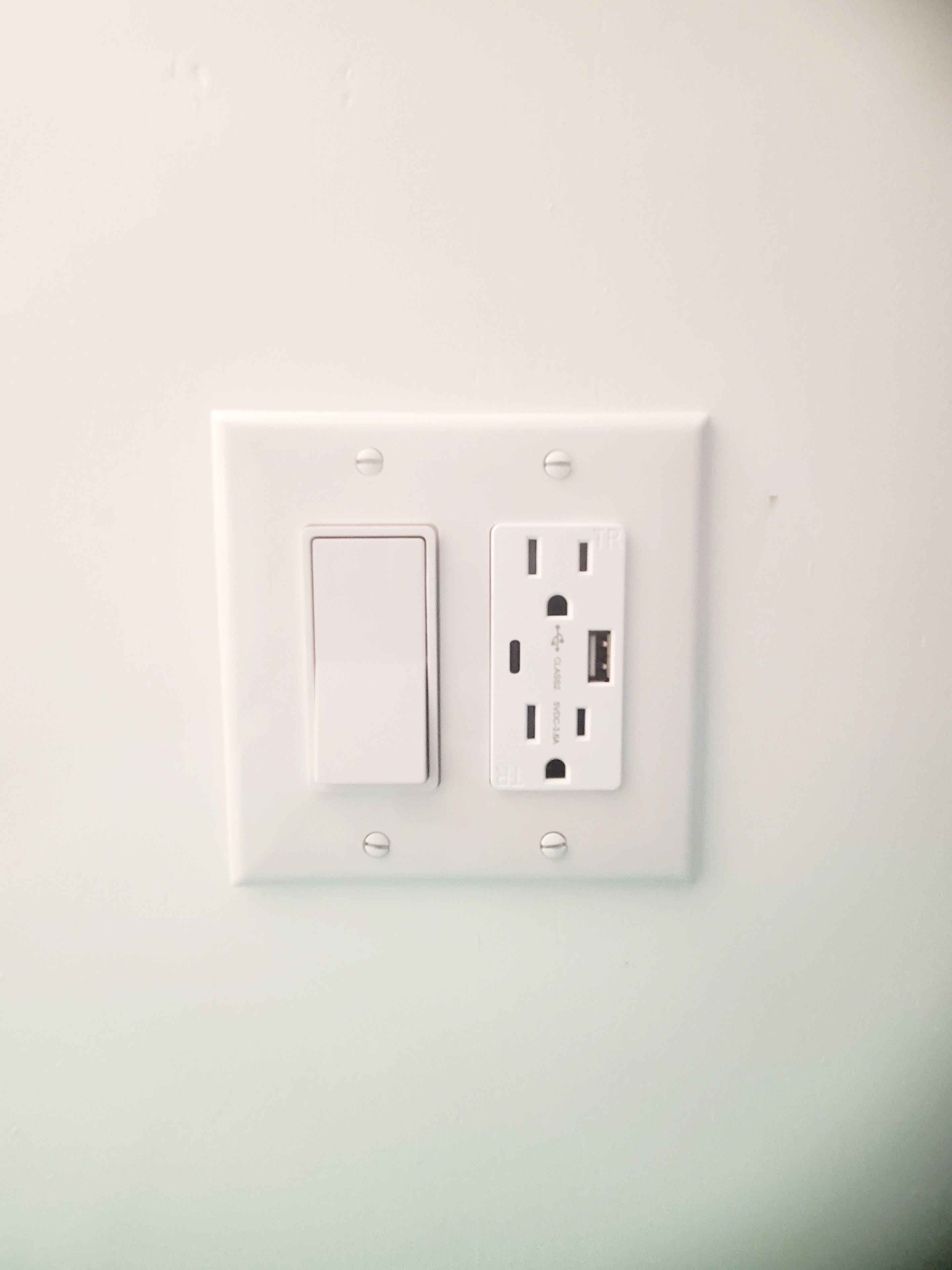 En hvid stikkontakt med standardafbryder og USB-port.