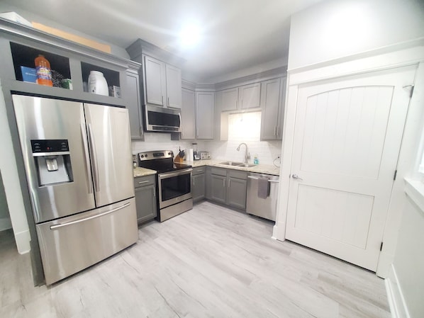 Enjoy cooking in this well-equipped kitchen with a refrigerator, oven, and microwave, plus a window above the sink.