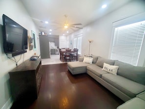 Relax in this stylish living room with a flat-screen TV, comfortable sofa, and dining area.