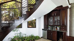 A modern kitchen with dark wood cabinets, a stainless steel dishwasher, and a built-in oven. - Playa Hermosa Luxe Villa • 4BR • 5BA • Infinity Pool & Ocean Views (Playa Hermosa)