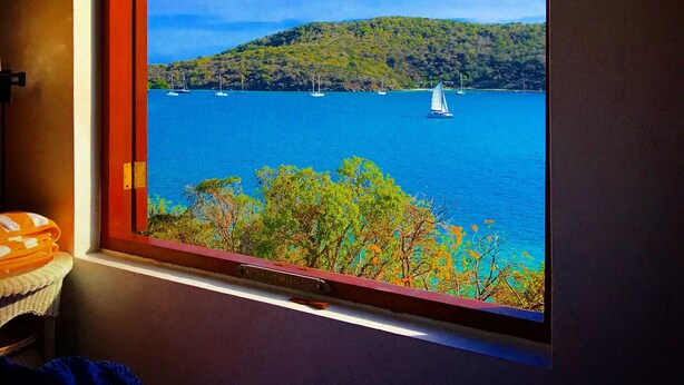 A window with a view of a lake, boats, and a forested hill. - Old World Caribbean with new world amenities (Belle Vue)