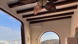 A room with a bed, a ceiling fan, a view of the sea, and a wooden ceiling. - Old World Caribbean with new world amenities (Belle Vue)