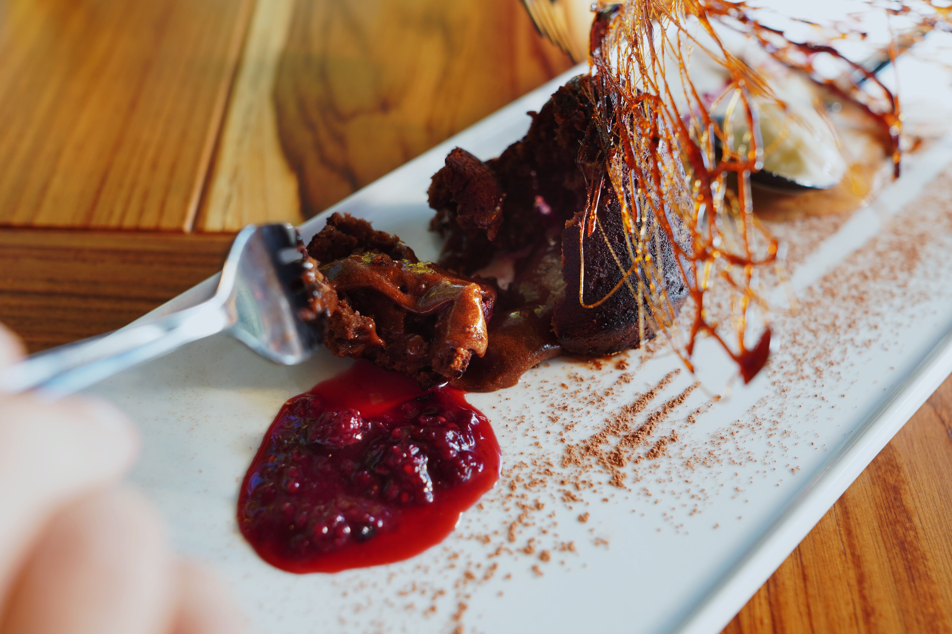 A white plate with a piece of meat and a spoon.