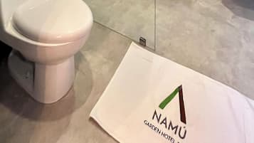 Un baño moderno con inodoro, cabina de ducha de vidrio y lavabo.