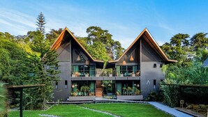A modern two-story house with a symmetrical design, large windows, and a well-maintained garden. - Namu Garden Hotel & Spa - Adults Only (Cahuita)