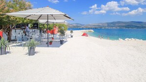 A beachside café with outdoor seating and a view of the sea. - A1 – seafront apt. with balcony, 1 min to beach (Trogir)