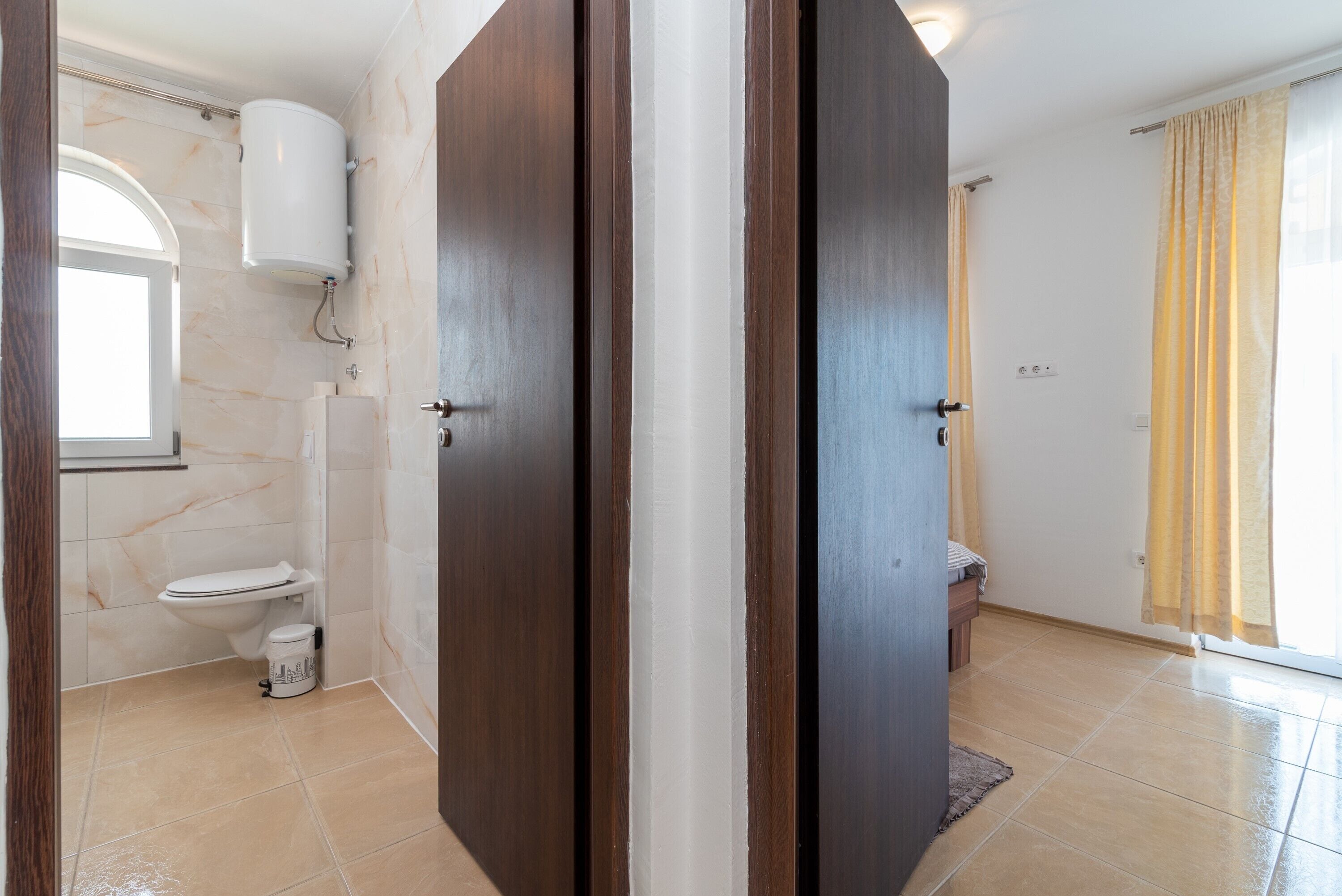 Ein Badezimmer mit Toilette, Dusche und Toilettenpapierhalter.