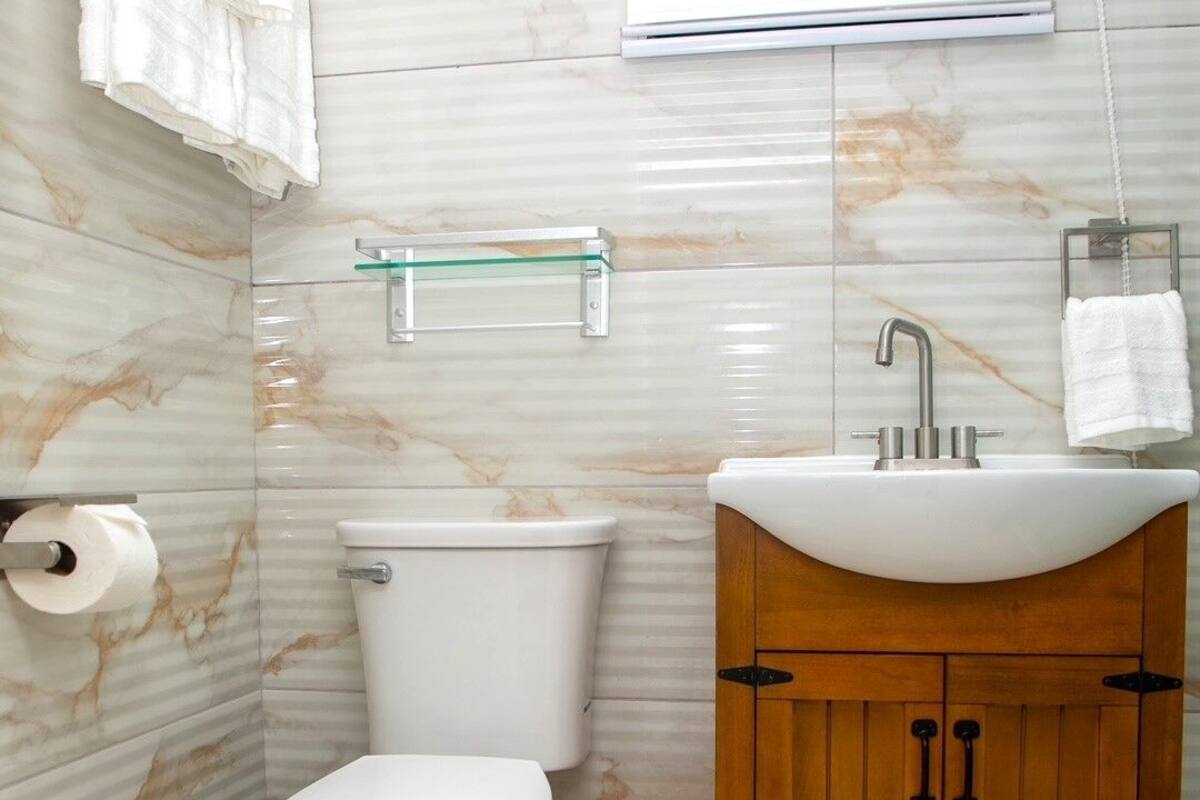 Ein Badezimmer mit Toilette, Waschbecken und Marmorwänden.