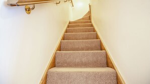 Eine Treppe mit Teppichstufen und einem Holnändergeländer.