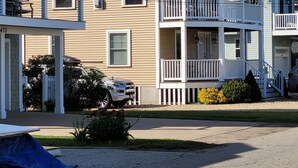 A multi-story building with a balcony on the second floor, a garage, and a driveway. - Great home minutes from beautiful Moody Beach, for the perfect beach vacation! (Wells)