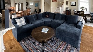 A spacious living room with a large sectional sofa, a coffee table, and a patterned rug. - Great home minutes from beautiful Moody Beach, for the perfect beach vacation! (Wells)