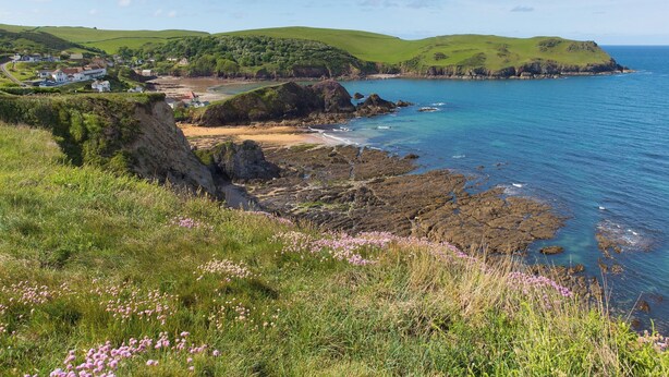 A coastal landscape with a village, green hills, and rocky coastline. - Smugglers Haunt - UK44513 (Hope Cove, near Kingsbridge)