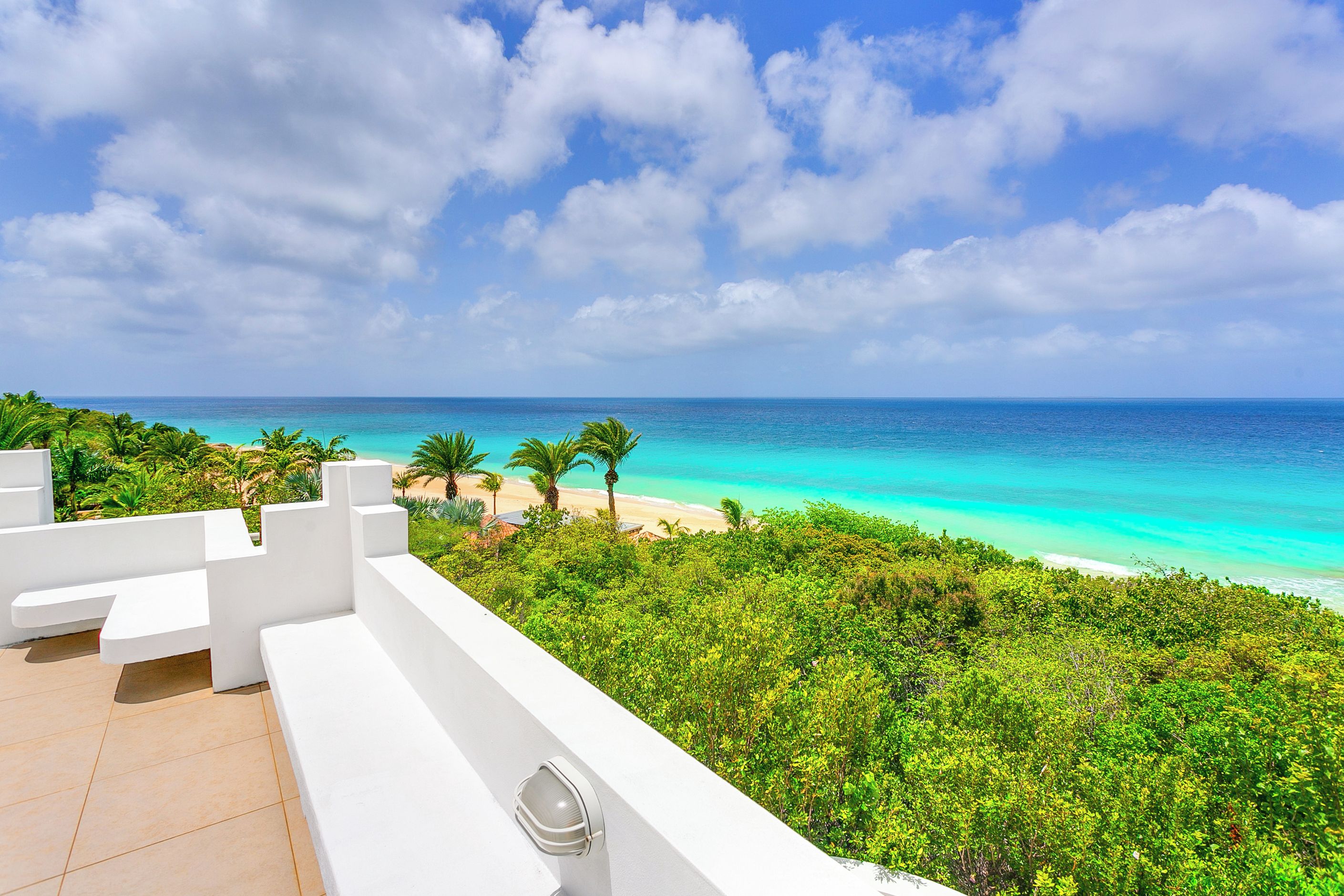 Un balcon avec vue sur une plage et l’océan.