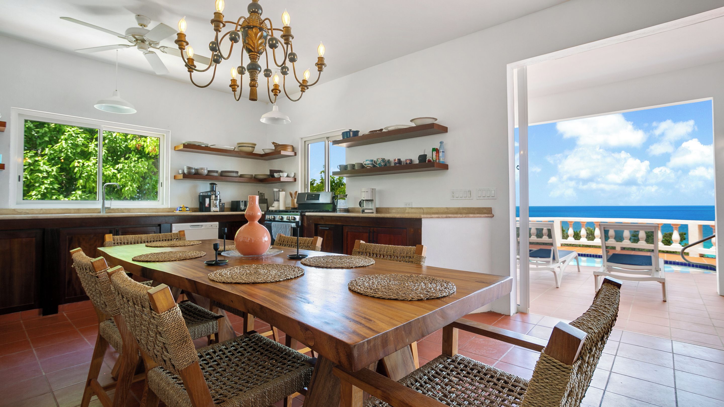 A spacious kitchen with a large island, modern appliances, and a view of the ocean.