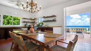 A spacious kitchen with a large island, modern appliances, and a view of the ocean.