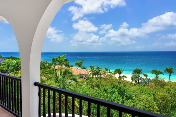 A balcony with a view of a beach and ocean.