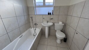 A bathroom with a bathtub, sink, and toilet.