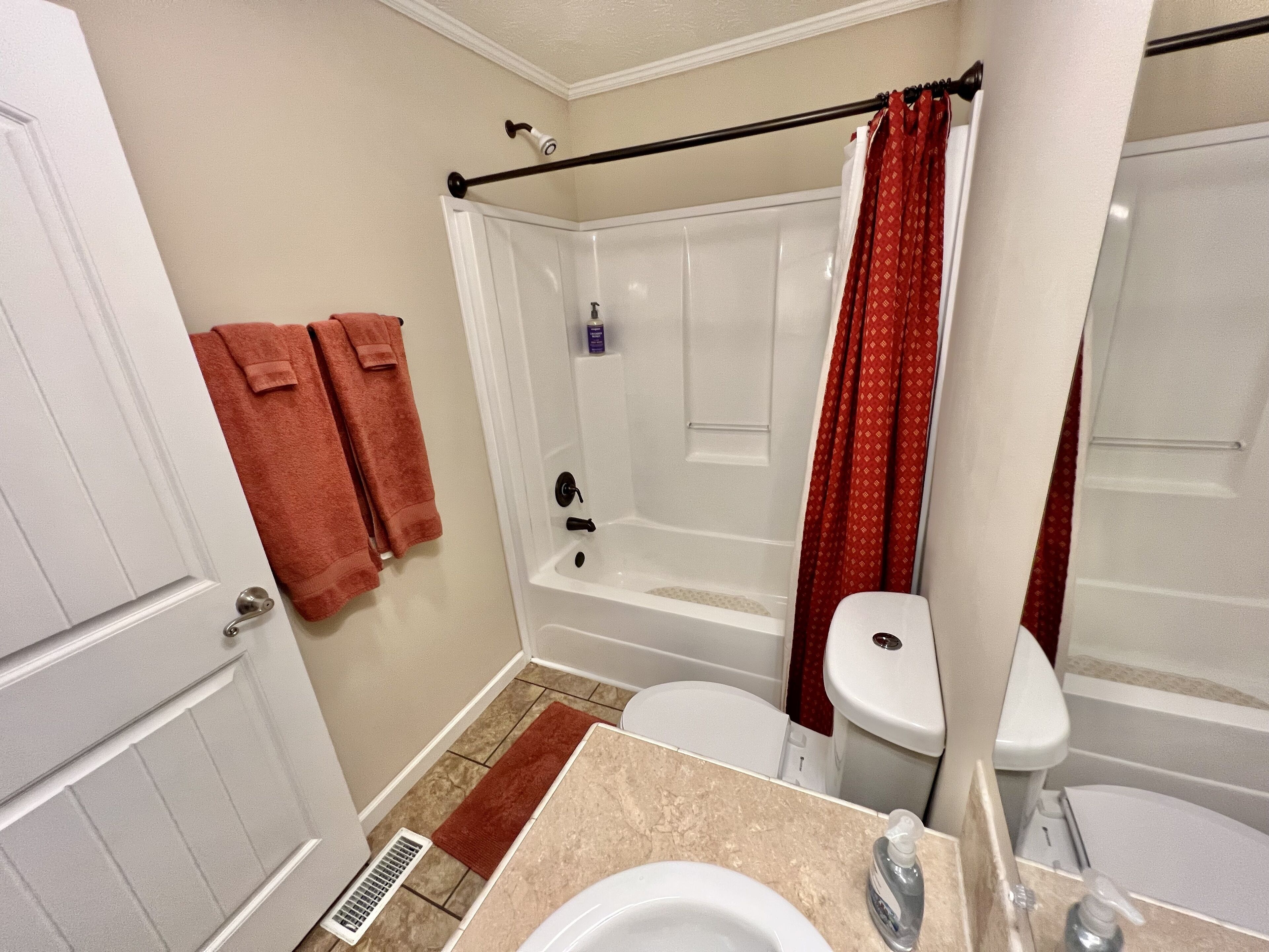 A bathroom with a bathtub, toilet, and sink.