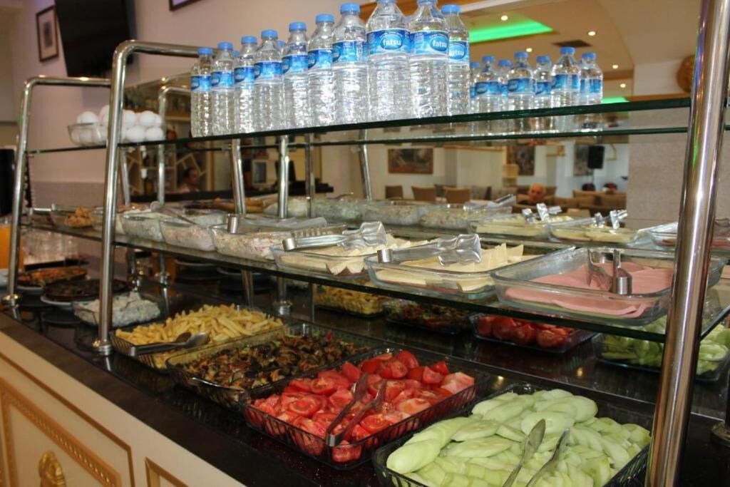 Un buffet proposant divers plats et des bouteilles d’eau.