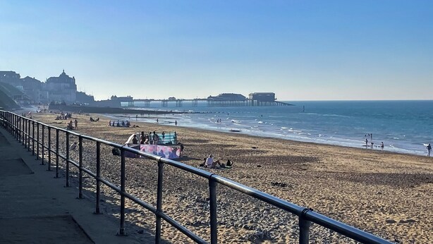 A beach with a promenade, a pier, and buildings in the background. - 2 bedroom accommodation in Cromer (Cromer)