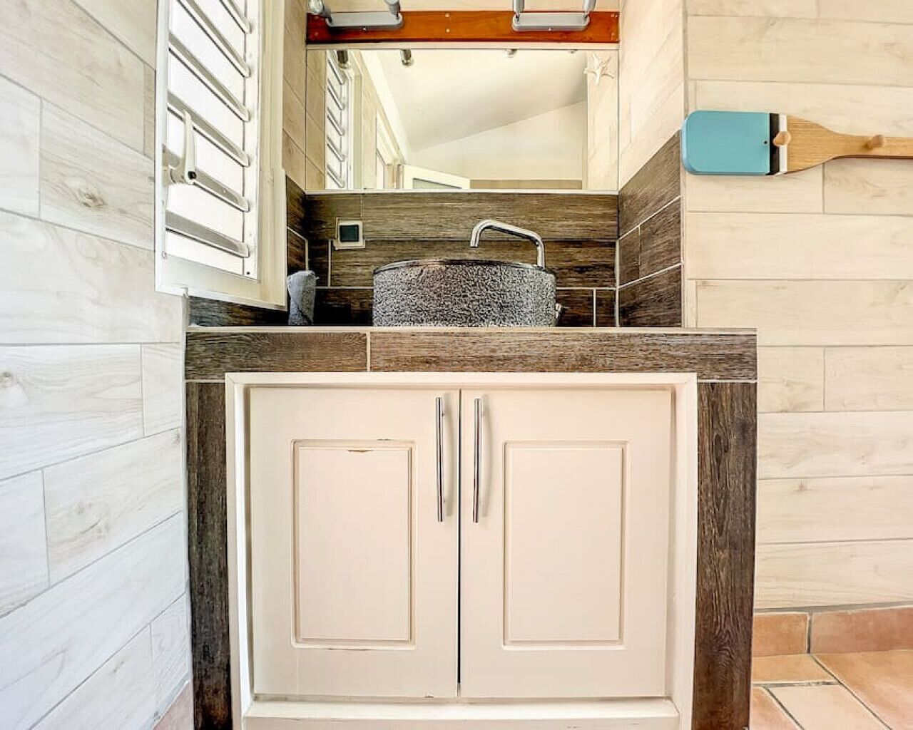 Cocina con un armario de dos puertas, un lavabo y una encimera de madera.