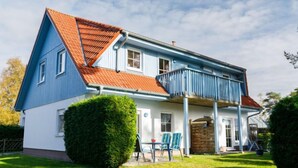A two-story house with a blue exterior and a red roof, featuring a covered porch with blue railings. - Apartment Berg by Interhome (Zinnowitz)
