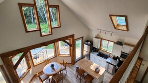 Eine Loft-Küche mit großen Fenstern, einem Essbereich und einer Treppe.