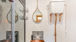 A bathroom with a wooden sink, a white toilet, a mirror, and a towel rack.