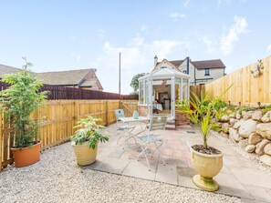 A patio area with a wooden fence, a gazebo, and potted plants. - 1 bedroom accommodation in Ellerdine, near Telford (Ellerdine, near Telford)