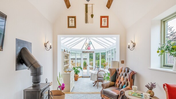 A cozy living room with a fireplace, a comfortable sofa, and a dining area with a table and chairs.