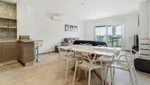 A modern kitchen with a dining area, a sofa, and a view of the outdoors. - WELCS APARTAMENTO 078 EMP  con inmejorables vista (Empuriabrava)