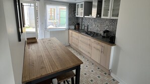 Una cocina moderna con una mesa de madera y armarios, vistas al exterior y un salpicadero de azulejos.