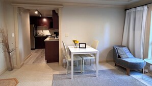 Un espace de vie compact comprenant un coin repas, une kitchenette et un coin salon avec un canapé.