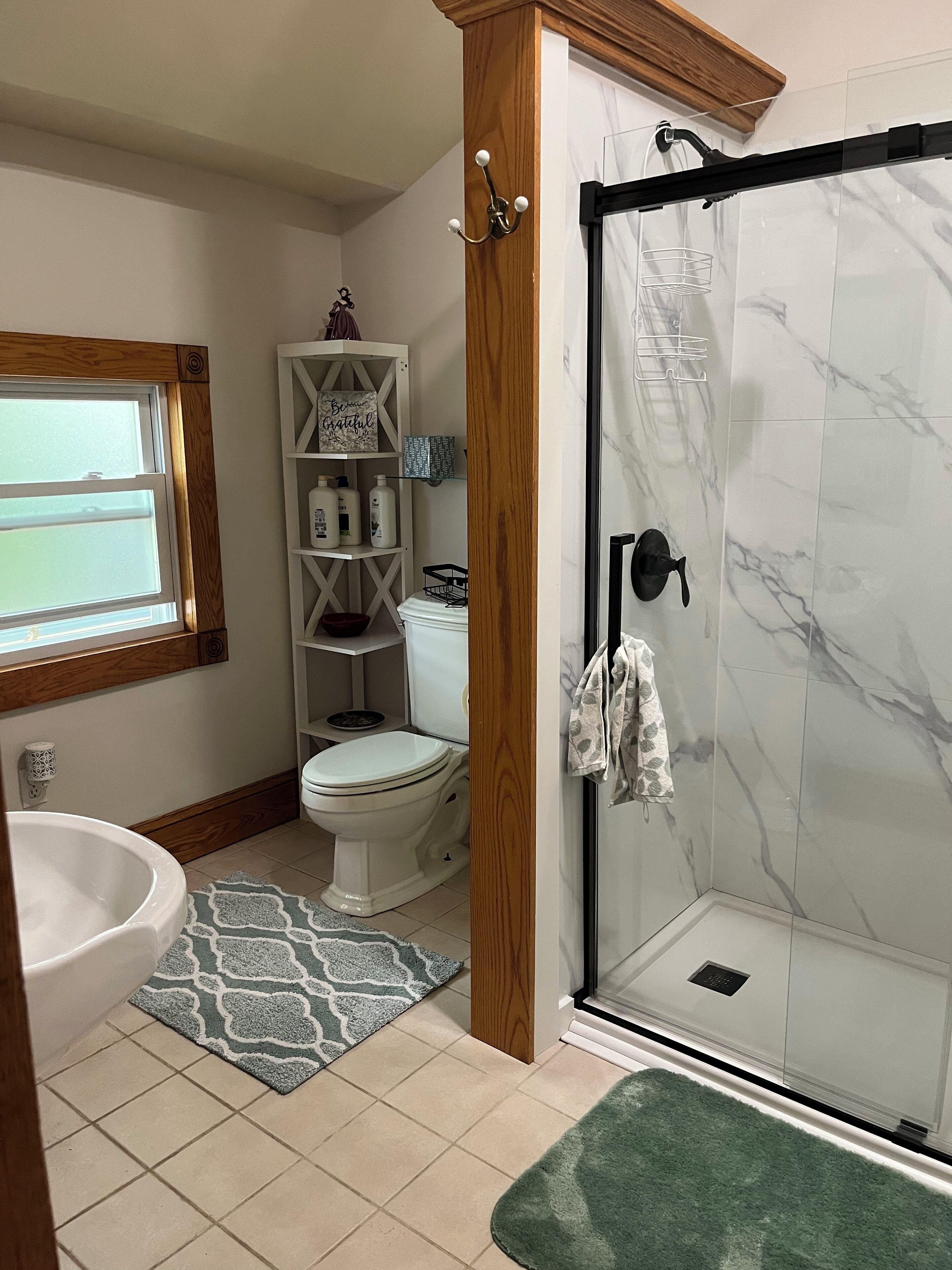 A bathroom with a bathtub, toilet, and a glass-enclosed shower.