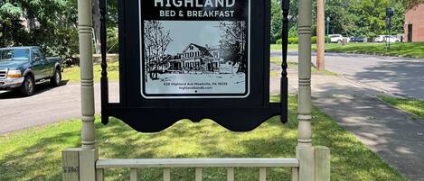 Naamplaatje voor Highland Bed & Breakfast met een zwart-witfoto van het gebouw, adres en website.