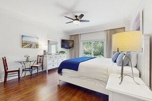 Relax in a spacious room with a large bed, flat-screen TV, and a desk area.